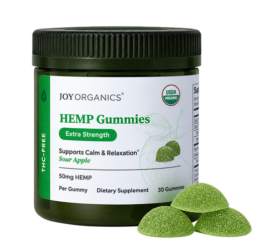 Dark green jar of Joy Organics hemp gummies with USDA organic label and three green sour apple-flavored gummies displayed in 